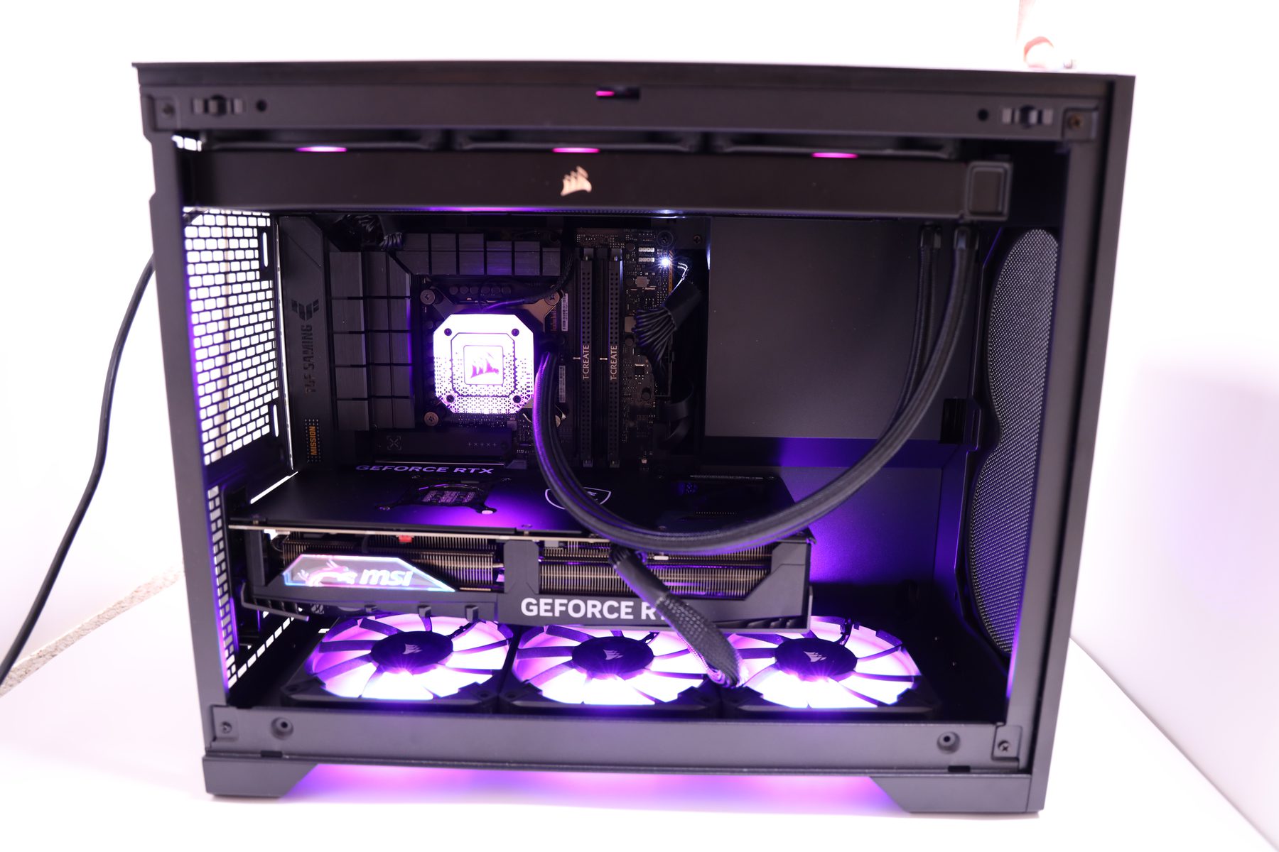 A finished build on the bench, side panel off, violet fans lit